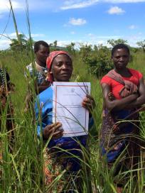 Stolt kvinna som visar upp kontrakt på landrättigheter