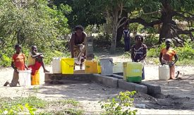 Damerna i byn vid pumpen. Männen satt bredvid och tittade på...